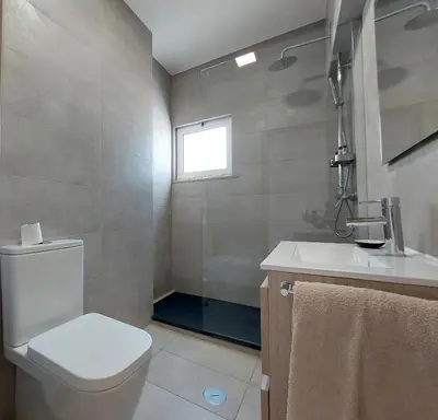 a bathroom with a toilet and a sink and a window at V2 - Bungalow 12 in Quarteira