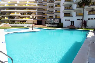 a swimming pool in front of a large apartment building at Al-Charb Retreat by SAPvillas in Quarteira