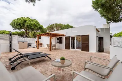 a patio with chairs and a table in front of a house at Terra Alba in Olhos de Água