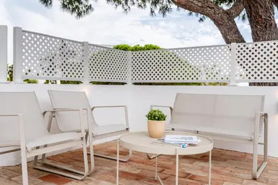 a white fence with two chairs and a table at Terra Alba in Olhos de Água