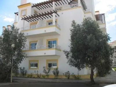 a large white building with a tree in front of it at T1 in Albufeira near Alfamar Hotel in Albufeira
