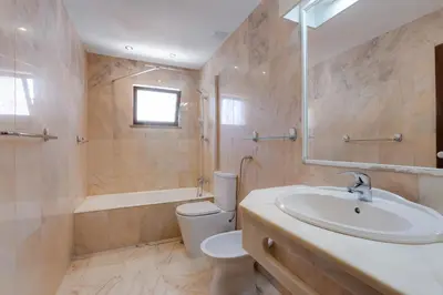 a bathroom with a sink and a toilet and a tub at Beachtime - Oura Beach Apartment in Albufeira