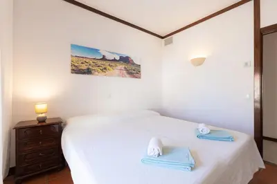 a bedroom with a white bed with towels on it at Beachtime - Oura Beach Apartment in Albufeira
