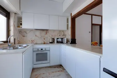a white kitchen with white cabinets and a sink at Beachtime - Oura Beach Apartment in Albufeira