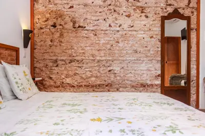 a bed in a room with a brick wall at Casa da Tita in Salir
