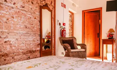 a bedroom with a bed and two chairs in a room at Casa da Tita in Salir
