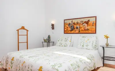 a bedroom with a bed with a painting on the wall at Casa da Tita in Salir