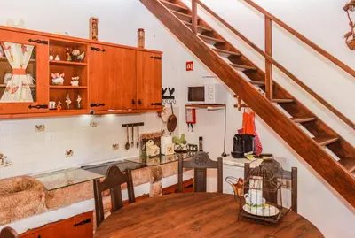 a kitchen with a wooden table and a staircase at Casa da Tita in Salir