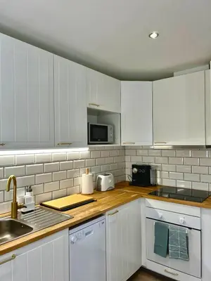 a kitchen with white cabinets and a sink at Delta Marina Vilamoura in Quarteira