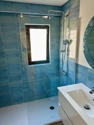 a bathroom with a sink and a shower with a window at Delta Marina Vilamoura in Quarteira