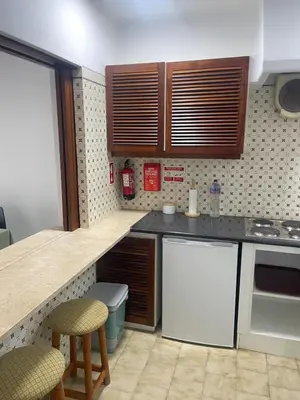 a kitchen with white appliances and wooden cabinets at Apartamento em São Rafael in Albufeira