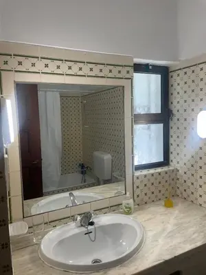 a bathroom with a sink and a large mirror at Apartamento em São Rafael in Albufeira
