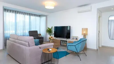 a living room with a couch and a tv at Terrazza Beach & Golf in Quarteira