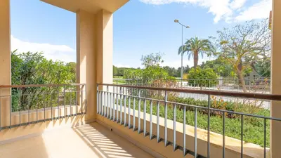a balcony with a view of a river and palm trees at Terrazza Beach & Golf in Quarteira