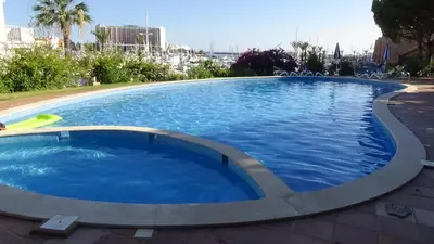 a large blue swimming pool with a frisbee in it at Beach Apartment Marina Vilamoura in Vilamoura
