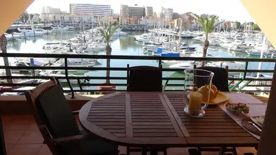 a table on a balcony with a view of a marina at Beach Apartment Marina Vilamoura in Vilamoura