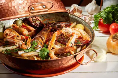 a large pot filled with seafood on a table at Beach Apartment Marina Vilamoura in Vilamoura