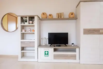 a living room with a television on a desk at Bloom Place VALE DO LOBO - Apartamento acolhedor com terraço in Vale do Lobo