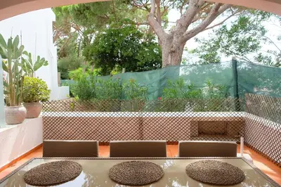 a patio with a table and chairs and a tree at Bloom Place VALE DO LOBO - Apartamento acolhedor com terraço in Vale do Lobo