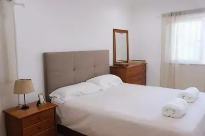 a bedroom with a white bed with a mirror and a dresser at Bloom Place VALE DO LOBO - Apartamento acolhedor com terraço in Vale do Lobo