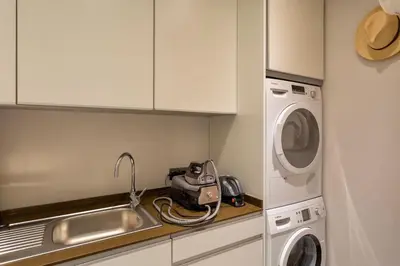 a kitchen with a sink and a washing machine at Deluxe Ancao in Almancil