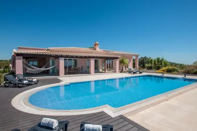 a swimming pool in front of a villa at Villa Mujeira in Loulé