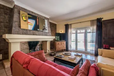 a living room with a red couch and a fireplace at Villa Mujeira in Loulé
