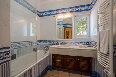 a bathroom with a sink and a tub and a mirror at Villa Mujeira in Loulé