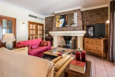 a living room with a pink couch and a fireplace at Villa Mujeira in Loulé