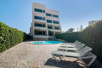 a lounge chair sitting in front of a building at Salgados Beach House in Albufeira