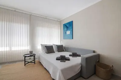 a bedroom with a large white bed with a window at Salgados Beach House in Albufeira