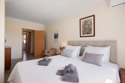 a bedroom with a bed and a dresser and a mirror at Salgados Beach House in Albufeira