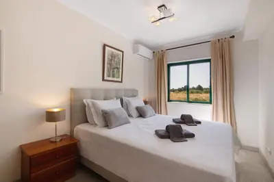 a bedroom with a large bed and a couch at Salgados Beach House in Albufeira