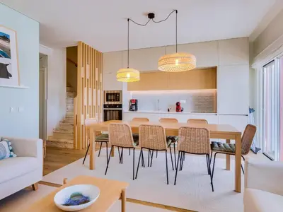 a kitchen and dining room with a table and chairs at Penthouse T4 com Vista Mar em Quarteira in Quarteira