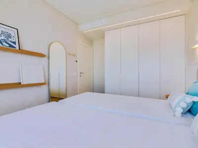 a white bedroom with a large white bed in it at Penthouse T4 com Vista Mar em Quarteira in Quarteira