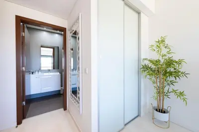 a bathroom with a large mirror and a plant at Beach 1Min! & Pool - Private Parking, AC & WiFi in Quarteira