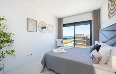 a bedroom with a bed and a large window at Beach 1Min! & Pool - Private Parking, AC & WiFi in Quarteira