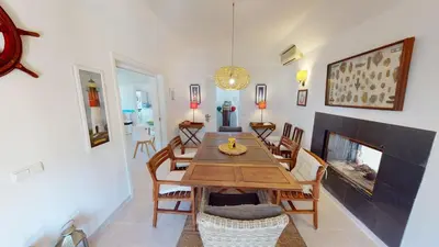 a dining room with a table and a fireplace at Villa Sunset,sleeps 9,heatable pool,walk to marina in Vilamoura