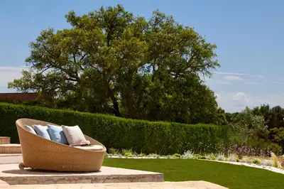 a rattan chair with pillows sitting in a garden at Casa Rosa dos Ventos in Guia