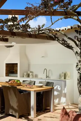 a kitchen with a wooden table and a tree at Casa Rosa dos Ventos in Guia