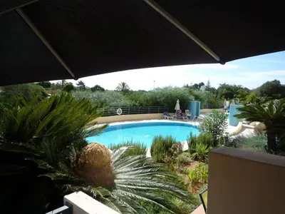 a swimming pool in a garden with palm trees at Luxury ground-floor appartment 5 stars, 2 bedrooms, 2 bathrooms, Free Wifi in Albufeira