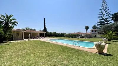 a swimming pool in a yard next to a house at Laranjal by Check-in Portugal in Quarteira