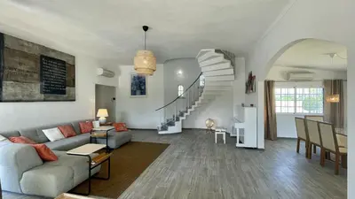 a living room with a couch and a staircase at Laranjal by Check-in Portugal in Quarteira