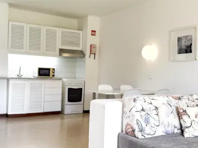 a living room with a couch and a kitchen at Aura Village - City Beach Apartments in Albufeira