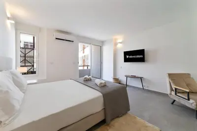 a white bedroom with a bed and a tv at Downtown Apartment - BE by HelloVacations in Albufeira