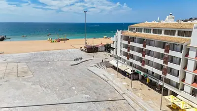 a view of a beach and a building and the ocean at Downtown Apartment - BE by HelloVacations in Albufeira