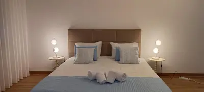 a bedroom with a large bed with three pillows at Faro Station Eleven Guest House in Faro