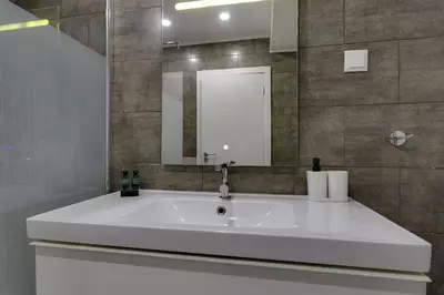 a bathroom with a large white sink and a mirror at CORCOVADA SUNSET Just 5 min from the Strip in Albufeira