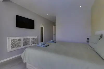 a bedroom with a large bed with a tv on the wall at CORCOVADA SUNSET Just 5 min from the Strip in Albufeira