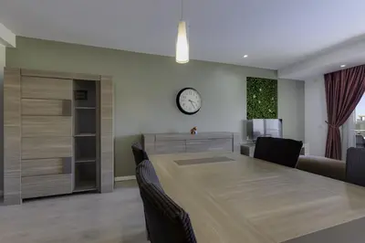 a dining room with a table and a clock on the wall at CORCOVADA SUNSET Just 5 min from the Strip in Albufeira